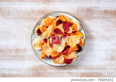 Vegetable chips, overhead shot on a plate, a healthy vegan snack 76804281