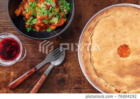 Portuguese cuisine. Alentejo style pork with porto sweet wine and a chicken pie 76804292