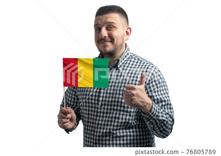 White guy holding a flag of Guinea and shows the class by hand isolated on a white background. Like for Guinea White guy holding a flag of Guinea and shows the class by hand isolated on a white background. Like for Guinea 76805789