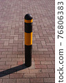 Car stop pole on brick-style paving stone pavement 76806383