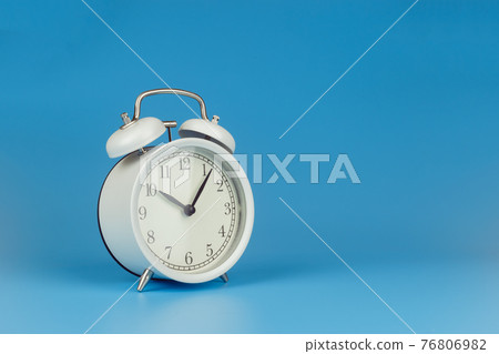 White alarm clock on blue background. White alarm clock on blue background. 76806982