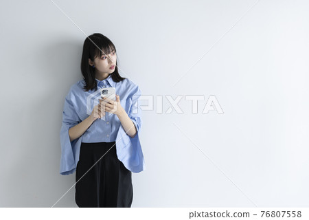A woman using a mobile phone A woman using a mobile phone 76807558