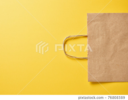 paper bag on yellow background paper bag on yellow background 76808389