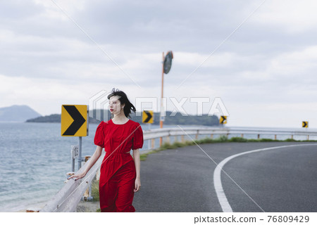 A woman walking along the beach A woman walking along the beach 76809429