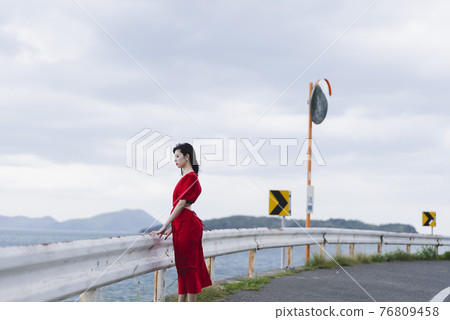 A woman walking along the beach A woman walking along the beach 76809458