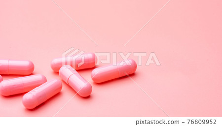 Pink capsules pill on pink background. Vitamins and supplements. Online pharmacy. Pharmacy store banner. Pharmaceutical industry. Woman's health insurance concept. Pills for love and happy life. 76809952