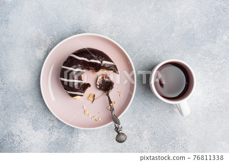 Donut in the glaze and a cup of coffee on the table. gray concrete table, copy space. 76811338