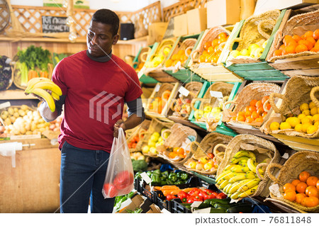 Man looking for vegetables and fruits in greengrocery 76811848