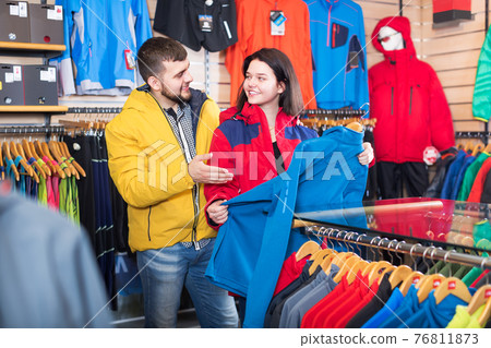 Couple choosing jacket in store Couple choosing jacket in store 76811873