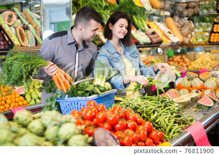 Ordinary couple examining various vegetables Ordinary couple examining various vegetables 76811900