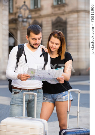 Smiling couple traveling with map and baggage Smiling couple traveling with map and baggage 76811906