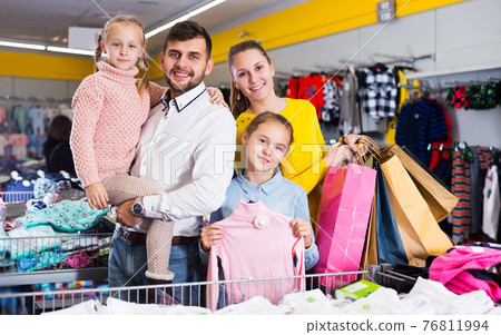 family of four with shopping bags 76811994