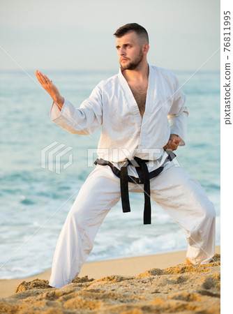 Ordinary male practising karate kata poses Ordinary male practising karate kata poses 76811995