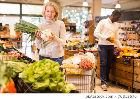 Woman buying vegetables in supermarket 76812676