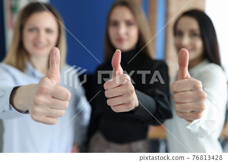 Three businesswoman are showing thumbs up gesture 76813428