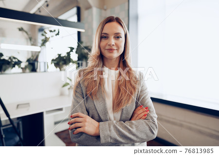 Portrait of a young businesswoman in formal outfit standing near window in office 76813985