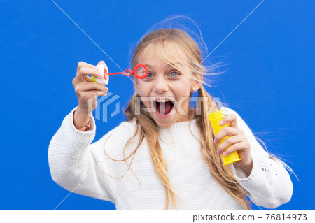 Funny girl blowing soap bubbles Funny girl blowing soap bubbles 76814973