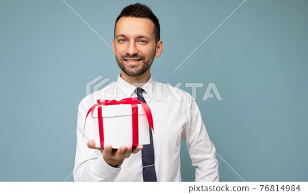 Photo shot of handsome happy smiling brunet young unshaven man isolated over blue background wall 76814984