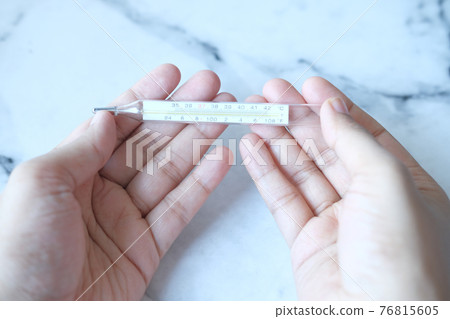 man hand holding medical thermometer  76815605
