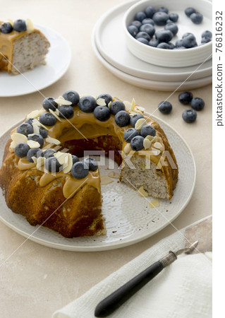 Bundt cake with peanut butter glaze. Healthy sugar gluten free cake with chia seeds decorated with blueberries and almond flakes. Bundt cake with peanut butter glaze. Healthy sugar gluten free cake with chia seeds decorated with blueberries and almond flakes. 76816232
