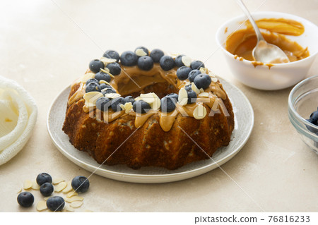 Bundt cake with peanut butter glaze. Healthy sugar gluten free cake with chia seeds decorated with blueberries and almond flakes. Bundt cake with peanut butter glaze. Healthy sugar gluten free cake with chia seeds decorated with blueberries and almond flakes. 76816233