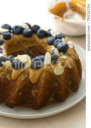 Bundt cake with peanut butter glaze. Healthy sugar gluten free cake with chia seeds decorated with blueberries and almond flakes. Bundt cake with peanut butter glaze. Healthy sugar gluten free cake with chia seeds decorated with blueberries and almond flakes. 76816234