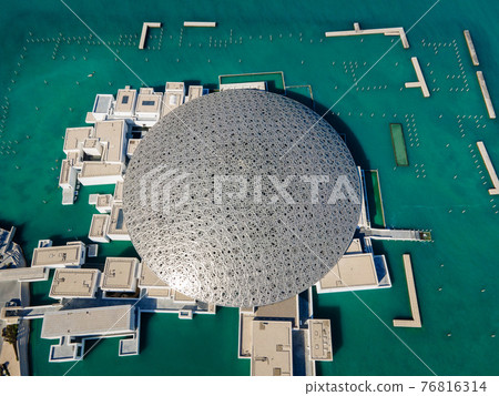 Louvre museum in Abu Dhabi emirate of the United Arab Emirates at sunrise aerial drone view of the building appear to float on the seaside 76816314