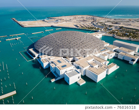 Louvre museum in Abu Dhabi emirate of the United Arab Emirates at sunrise aerial drone view of the building appear to float on the seaside 76816318