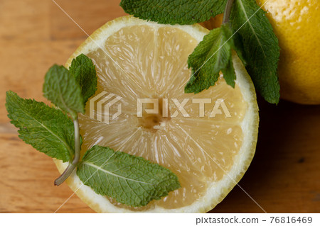 fresh half lemon with mint leaves on a wooden table fresh half lemon with mint leaves on a wooden table 76816469
