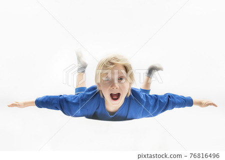 Surprised boy is flying or falling in the air. Free fall. White background Surprised boy is flying or falling in the air. Free fall. White background 76816496