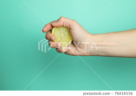 Female hand hold lime on mint background Female hand hold lime on mint background 76816556