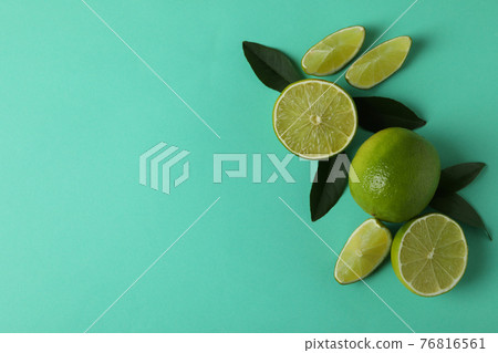 Fresh limes and leaves on mint background Fresh limes and leaves on mint background 76816561