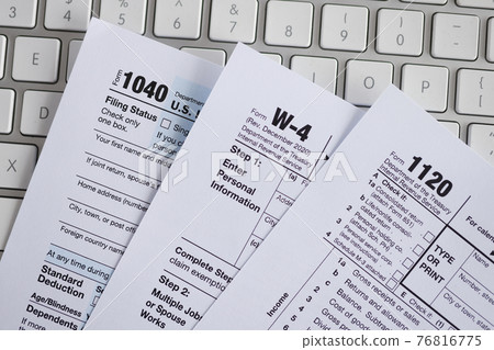 Tax form documents lying on computer keyboard closeup Tax form documents lying on computer keyboard closeup 76816775