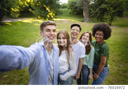 Group of multiethnical teen friends talking selfie outdoors in park 76816972