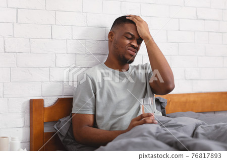 Black Guy Suffering From Headache Sitting In Bed At Home Black Guy Suffering From Headache Sitting In Bed At Home 76817893