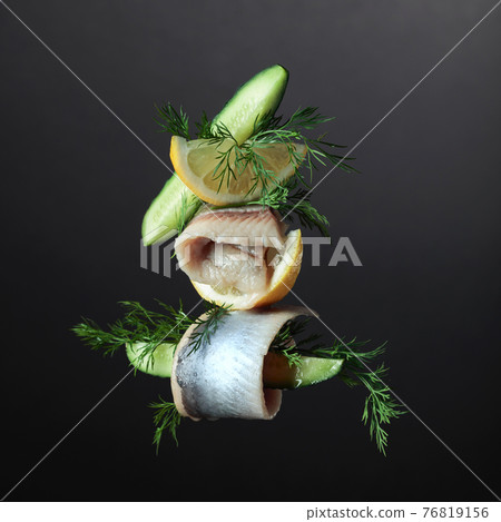 Herring fillet in oil with lemon, cucumber, and dill. 76819156