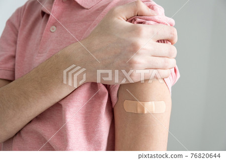 plaster on the arm after vaccination against COVID-19 infection. Vaccination against coronavirus. 76820644