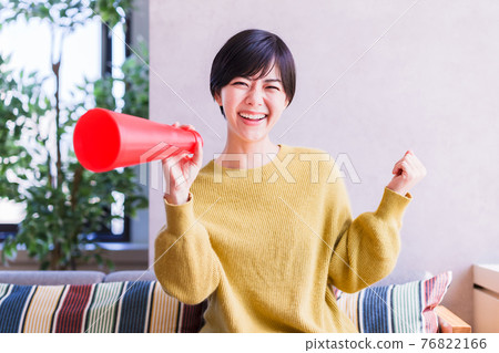 A young woman watching sports on TV [Corona Sorrow New Normal] 76822166