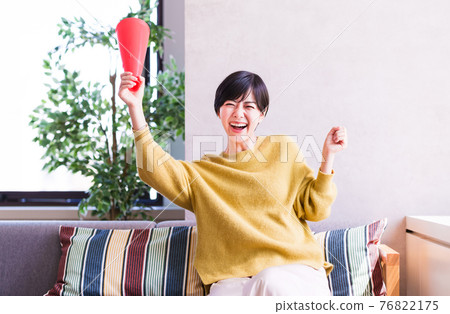 一位年輕女子在電視上看體育節目 [Corona Sorrow New Normal] 76822175