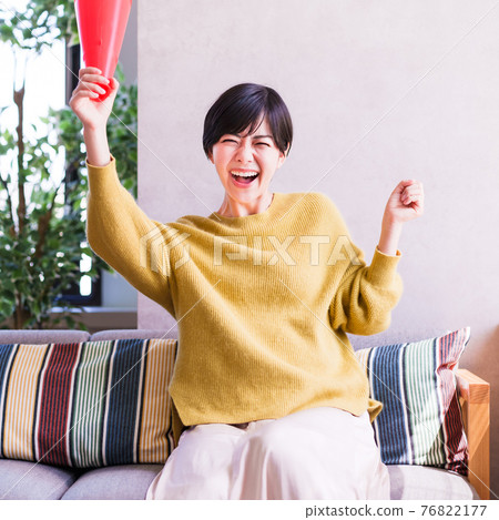 A young woman watching sports on TV [Corona Sorrow New Normal] 76822177