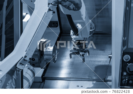 The robotic arm gripping the metal part. 76822428