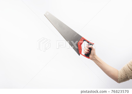 Saw in a female hand. Isolated on white background. 76823570