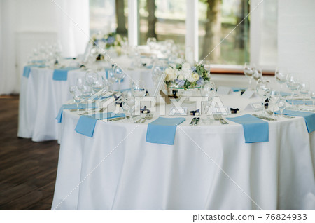 wedding table decoration with blue flowers on the table in the restaurant table decor for dinner at the wedding. 76824933