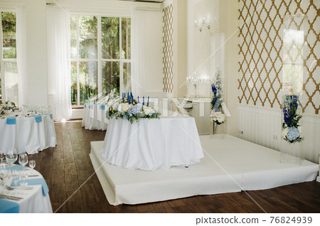 wedding table decoration with blue flowers on the table in the restaurant table decor for dinner at the wedding. 76824939