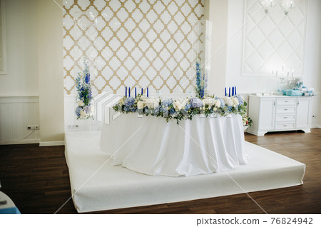 wedding table decoration with blue flowers on the table in the restaurant table decor for dinner at the wedding. 76824942
