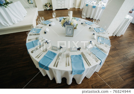 wedding table decoration with blue flowers on the table in the restaurant table decor for dinner at the wedding. 76824944