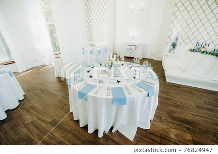 wedding table decoration with blue flowers on the table in the restaurant table decor for dinner at the wedding. 76824947