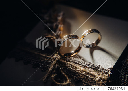 Close-up of two gold wedding rings for a wedding 76824984