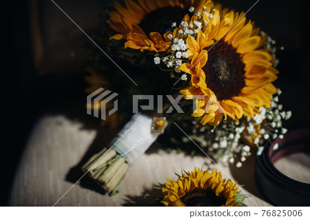 a wedding bouquet of sunflowers lies on an antique chair.Wedding Decor a wedding bouquet of sunflowers lies on an antique chair.Wedding Decor 76825006