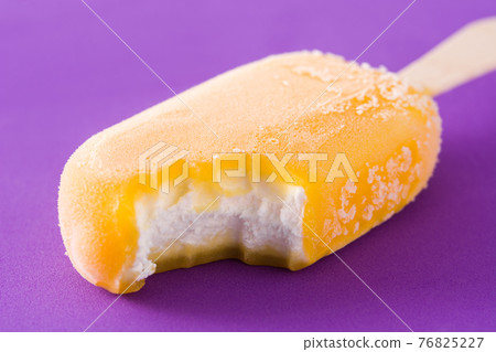 Orange popsicle on violet background 76825227